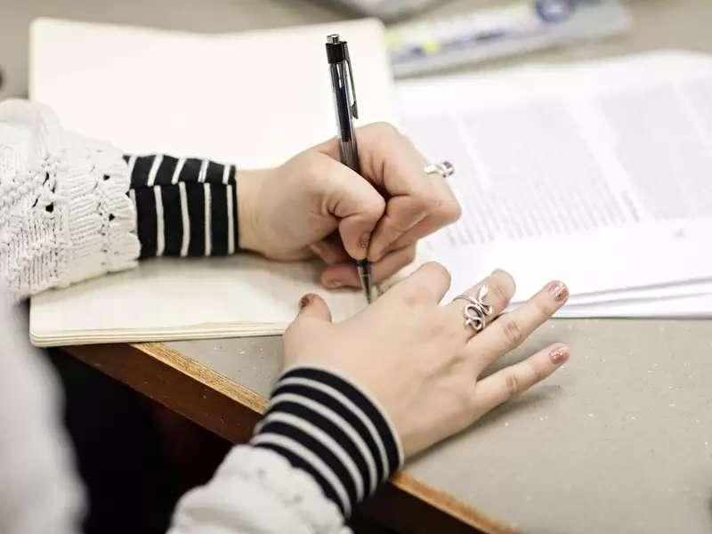 关闭-up of a person's hands writing on paper